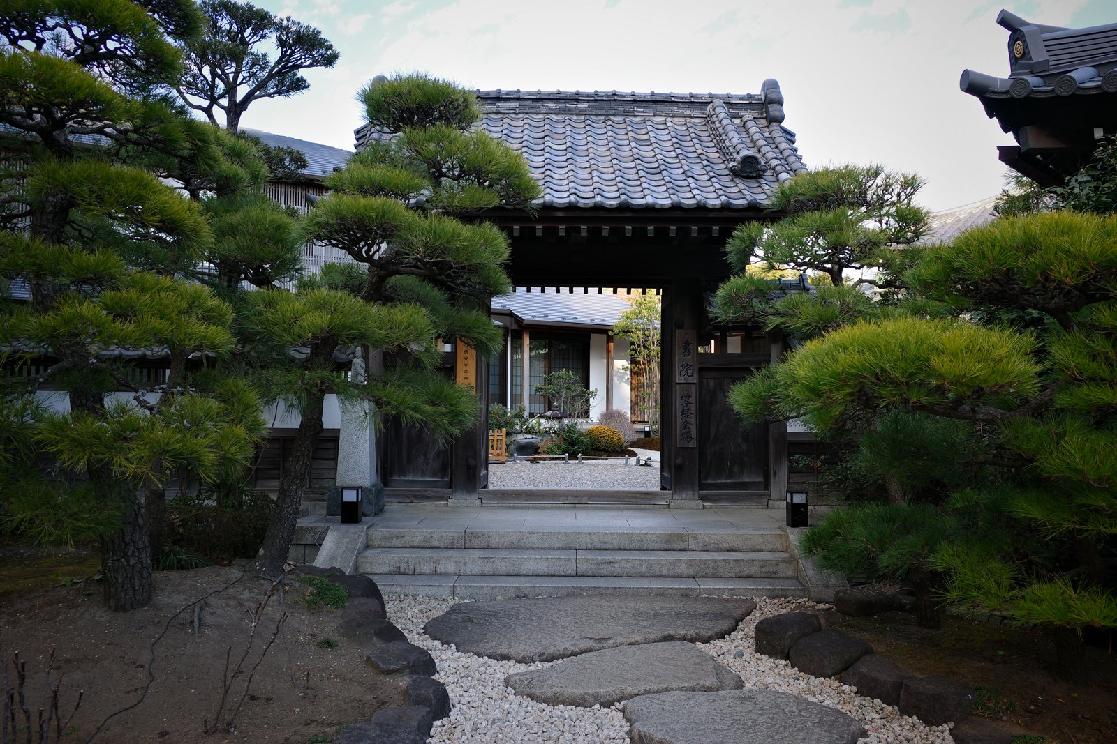 temple gate framed by manicured pines