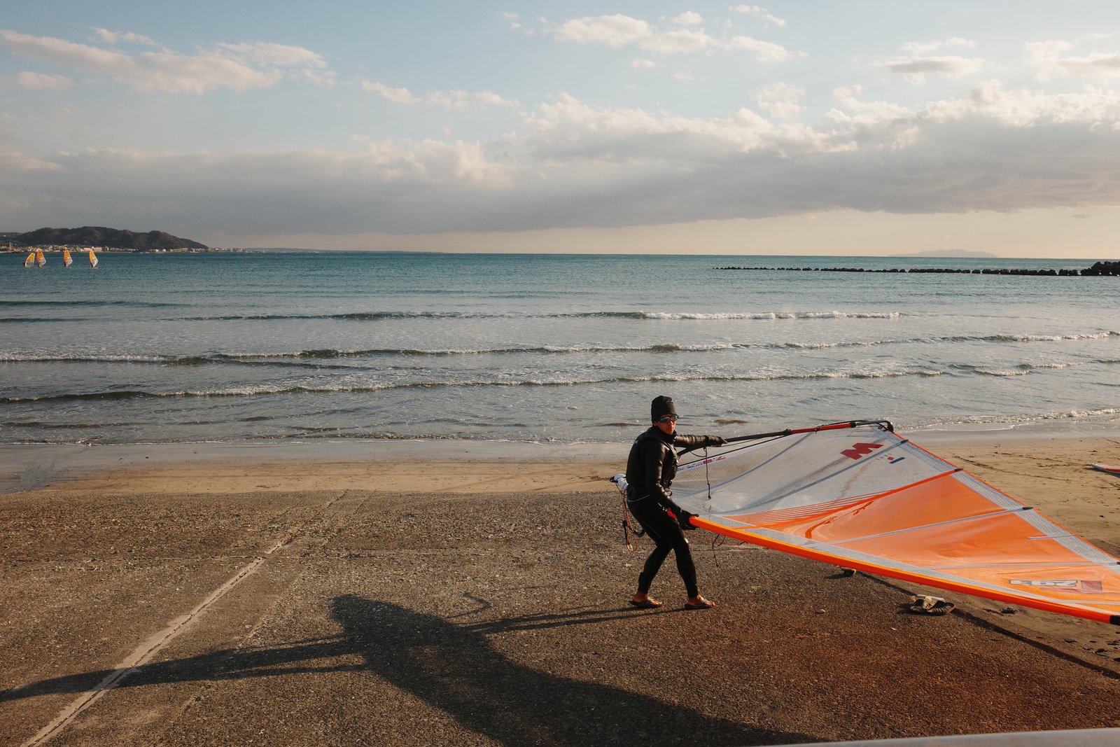 windsurfer carrying a sail on shonan beach